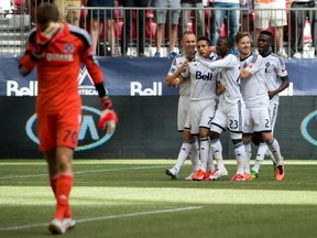 Camilo celebrates with his Whitecaps teammates as Chicago goalkeeper Paolo Tornaghi shows his frustration. (THE CANADIAN PRESS/Darryl Dyck)