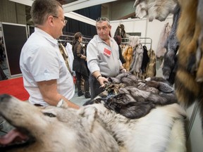 Dealer Gaston Henry left speaks with a buyer at his booth during Montreal's fur trade show at Place Bonaventure in April. (POSTMEDIA NEWS FILES)