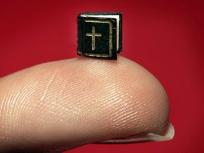 A miniature book containing The Lord’s Prayer is displayed at Christie’s on March 9, 2006, in London. The book is five millimetres square. (GETTY IMAGES FILES)