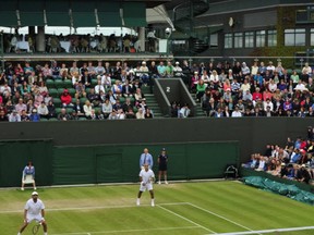 John McEnroe serves on July 3, 2013, at Wimbledon. Getty Images photo.