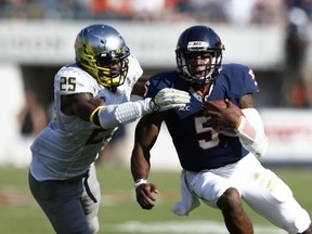 Oregon linebacker Boseko Lokombo prepares to put the stop on Virginia's David Watford last Saturday. (Getty Images photo)