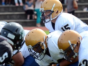 Rick Hansen quarterback Alex Ho looks over his offensive line Friday in crosstown derby with rival Robert Bateman. (Jean Konda-Witte, The Abbotsford Times)