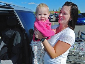 Paige Barnet, lifting her infant daughter into her vehicle at Southgate Centre in Edmonton, says she never leave the little girl unattended. (POSTMEDIA NEWS FILES)