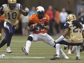 BC Lions' Andrew Harris steps between some Blue Bombers on Aug. 5 at BC Place.
