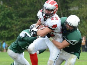 Lord Tweedsmuir Panthers Amrit Sanopal (left) and Jeff Godard sandwich John Barsby running back Brandon Parker on Friday in Surrey. (PNG photo)