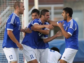 UBC Thunderbirds' Milad Mehrabi (second from right) celebrates his goal Friday night as the defending CIS champions opened the 2013 Canada West conference season with a resounding 4-1 win over the host Victoria Vikes. (Photo -- Armando Tura, University of Victoria athletics)