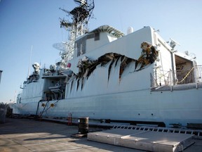 Royal Canadian Navy warship HMCS Algonquin sits in port with significant damage to her port side hangar at CFB Esquimalt on Sunday, Sept. 1. following a collision with the HMCS Protecteur during a close-quarters training exercise. (THE CANADIAN PRESS)