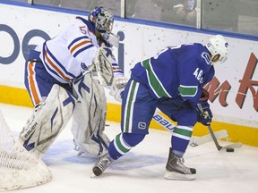 Edmonton Oilers goalie Franky Palazzese is stripped of the puck during a prospects game on Sept. 8 by Canucks' Niklas Jensen. Jensen hasn't fared as well with the top squad.