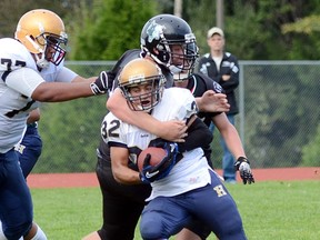 Rick Hansen Hurricanes' running back Devin DaCosta battles through the defensive heat of the Robert Bateman Timberwolves on Friday afternoon in Abbotsford. (Jean Konda-Witte, The Abbotsford Times)