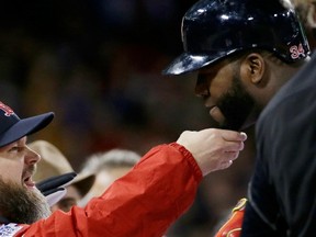 The Boston Red Sox’s David Ross, left, tugs on David Ortiz’s beard after Ortiz hit a two-run home run off of St. Louis Cardinals starting pitcher Michael Wacha during the sixth inning of Game 2 of the World Series on Thursday. (THE ASSOCIATED PRESS)