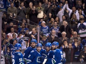 The Vancouver Canucks celebrate a goal scored by Daniel Sedin on Oct. 30, 2013. Canadian Press photo.