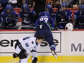 The Vancouver Canucks' Alex Edler cross-checks the San Jose Sharks' Tomas Hertl in the head on Oct. 10, 2013, in Vancouver. PNG photo.