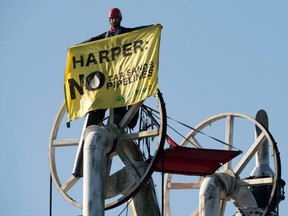 Greenpeace activist holds up a banner during a blockade at the Kinder Morgan facility on Burrard Inlet in Burnaby on Oct. 16. (THE CANADIAN PRESS)