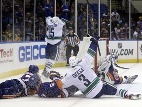 Kevin Bieksa of the Vancouver Canucks celebrates Brad Richardson's winning goal in overtime against the New York Islanders on Oct. 22, 2013. Getty Images photo.