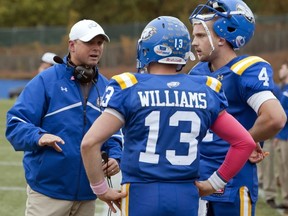 UBC Thunderbirds' head coach Shawn Olson confers with his two quarterbacks, Carson Willams and Greg Bowcott, during Saturday's record-setting 60-0 win over Alberta at Thunderbird Stadium. (Richard Lam, UBC athletics)