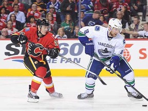 Ryan Stanton keeps the puck away from the Flames' Jiri Hudler Sunday night in Calgary.