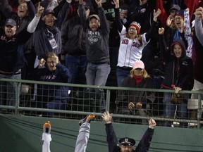Torii Hunter of the Detroit Tigers topples over the fence at Fenway Park on Oct. 14, 2013. Stan Grossfeld, Boston Globe via AP.