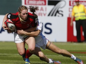 Camille Grassineau (R) of France tackles Kayla Moleschi (L) of Canada during their International Rugby Board (IRB) Women's Sevens World Series rugby union match in the Gulf emirate of Dubai on November 28, 2013. AFP PHOTO/KARIM SAHIB        (Photo credit should read KARIM SAHIB/AFP/Getty Images)