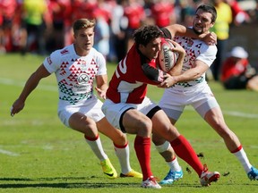 DUBAI, UNITED ARAB EMIRATES - NOVEMBER 29: Mike Scholz of Canada is tackled by Mat Turner of England during the Dubai Sevens match between England and Canada, as part of the second round of the HSBC Sevens World Series at The Sevens stadium on November 29, 2013 in Dubai, United Arab Emirate. (Photo by Francois Nel/Getty Images)