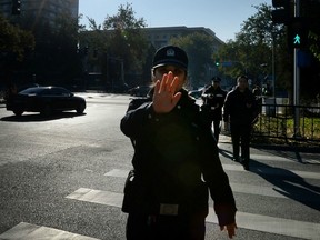 Police officer tries to stop photographer Tuesday in Beijing outside secret meeting of the Communist Party Central Committee, which runs the police state. (AFP/GETTY IMAGES)