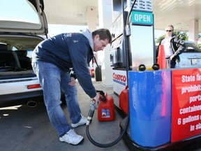 J.F. Cloutier of Richmond, fills up fuel cannisters at the Costco gas bar in Bellingham, Wash., to avoid high-tax gas in B.C. He says he saves about $70 a month by buying and stocking up on gas in the U.S. (Kim Stallknecht/PNG)