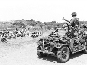 U.S. military personnel guard Cuban Nationals captured during Operation Urgent Fury, the 1983 U.S. invasion of Grenada. (U.S. National Archives)