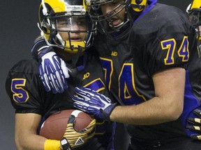 Mt. Douglas Rams' running back Marcus Davis (left) shares a moment with offensive lineman Aarmin Purewal during Saturday's Subway Bowl finals win over Terry Fox at BC Place. (Gerry Kahrmann, PNG photo)