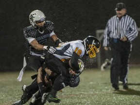 Frank Hurt's Bash Sise-Odaa is slowed by Mission's Jesse Walker (top) and Inder Herr during Subway Bowl quarterfinal contest Friday in rainy Abbotsford. (Rod Wiens photo)