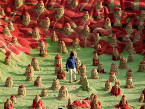 Sand artist Sudersan Pattnaik works on a 2012 sand sculpture with over 500 Santa Claus statues at Golden Beach in Puri, a city on the east coast of India on the Bay of Bengal. (AFP FILES)