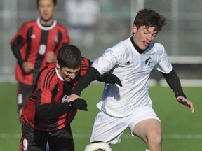 Camilo Trujillo (left) of North Vancouver's St. Thomas Aquinas Fighting Saints, battles with Okanagan Mission Huskies' Noah Van Demark in Wednesday's B.C. senior boys Double A soccer championships held at the Burnaby Lake Sports Complex. The Fighting Saints won its sixth straight sudden-elimination game of the post-season, 1-0 (4-3) on penalty kicks to claim its first boys soccer title in 11 years. (Jason Payne, PNG photo)