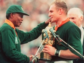 South African rugby team captain, Francois Pienaar (R), is congratulated by South African President Nelson Mandela (L) after South Africa won the Rugby World Cup final against New Zealand 24 June 1995 in Johannesburg.        (Photo credit should read JEAN-PIERRE MULLER/AFP/Getty Images)