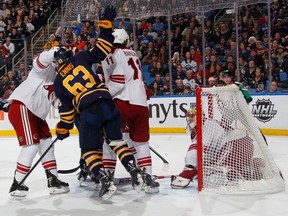 BUFFALO, NY - DECEMBER 23: Tyler Ennis #63 of the Buffalo Sabres reacts as goaltender Mike Smith #41 of the Phoenix Coyotes slides into the net with the puck on the overtime winning goal by Mark Pysyk (not shown) on December 23, 2013 at the First Niagara Center in Buffalo, New York. Buffalo won, 2-1. (Photo by Bill Wippert/NHLI via Getty Images)