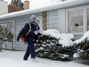 Canada Post letter carrier delivers mail to houses in Regina on Wednesday, Dec. 11, 2013, the day Canada Post announced it would be eliminating door-to-door service and increasing the price of stamps. (POSTMEDIA NEWS FILES)