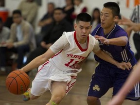 Sir Charles Tupper Tigers' guard Henry Pham (left) tries to drive past Kelly Chow of the Vancouver College Fighting Irish on Wednesday. (Gerry Kahrmann, PNG photo)