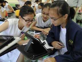 Singapore students, here using an iPad in a language arts class at Nanyang Girls’ High School, are among the top high school math students in the world. (AFP FILES)