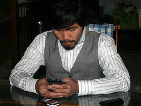 Philippine boxing superstar Manny Pacquiao browses his cellular telephone at his house in General Santos City, in southern island of Mindanao on May 12, 2010. World boxing champion Manny Pacquiao said May 12, he was finally ready to fight Floyd Mayweather for the last professional bout of his career and potentially the richest in history.Pacquiao made the announcement about the potential Mayweather clash, which US promoter Bob Arum said could take place on November 13 in Texas or Las Vegas, after winning a seat in the Philippine parliament.  AFP PHOTO/PAUL BERNALDEZ (Photo credit should read PAUL BERNALDEZ/AFP/Getty Images)(Photo Credit should Read /AFP/Getty Images)
