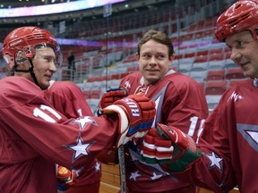 Russian President Vladimir Putin cheers with  Pavel Bure (C) during a hockey game with the stars of Soviet hockey in Sochi on January 4, 2014.        (Photo credit ALEXEY NIKOLSKY/AFP/Getty Images)