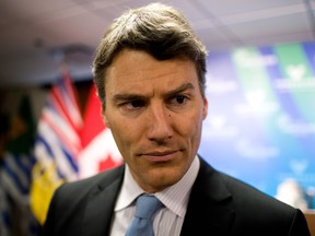 Mayor Gregor Robertson pauses while speaking to reporters after announcing openly gay Vancouver city councillor Tim Stevenson would represent the city at the 2014 Sochi Olympics, during a news conference in Vancouver, B.C., on Wednesday December 11, 2013. (Darryl Dyck/CP)