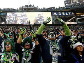 SEATTLE - DECEMBER 22:  Fans of the Seattle Seahawks cheer against the Arizona Cardinals on December 22, 2013 at CenturyLink Field in Seattle, Washington.  (Photo by Jonathan Ferrey/Getty Images)