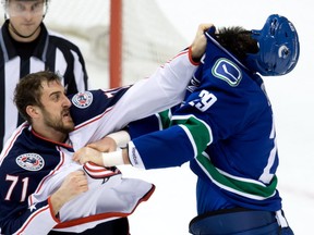 The Vancouver Canucks' Tom Sestito fights the Columbus Blue Jackets' Nick Foligno. CP file photo.