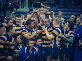 UBC captain Ben Grant raises the Wightman Boot, cheered on by his teammates.
