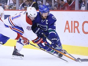 The newest Canuck, Raphael Diaz, battles against Canucks captain Henrik Sedin during a Montreal Canadiens visit to Rogers Arena in October.
