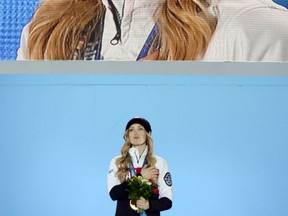 Canadian gold medalist Justine Dufour-Lapointe cries -- but keeps her hat on -- as she listens to O Canada during the medal ceremony for the women's freestyle skiing moguls event. (AFP PHOTO)