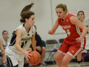 Michelle Bos (right) of Surrey's Holy Cross Crusaders, stays with Sarah Buckingham of crosstown rival and host Lord Tweedsmuir Panthers on Tuesday evening during senior girls Triple A basketball game won 79-39 by the Crusaders. Bos is set to play CIS basketball next season with Kamloops' Thompson Rivers WolfPack. (Photo -- Howard Tsumura, PNG)