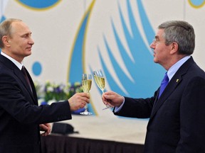 Russian president Vladimir Putin and IOC president Thomas Bach enjoy a glass of champagne post-Sochi on Feb. 24, 2014. AFP photo.