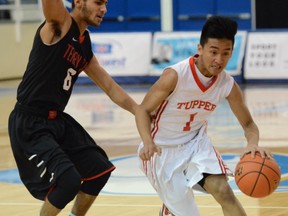 DJ Sugue (right) of the Tupper Tigers, cuts past Skander Hmaied of the Terry Fox Ravens during Eastside Story hoops clash Saturday at UBC.