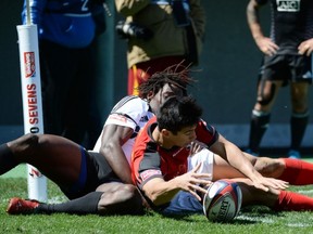 Sean Duke of Canada scores a try against Portugal despite the efforts of Aderito Esteves  (TOSHIFUMI KITAMURA/AFP/Getty Images)