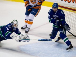 Vancouver Canucks defenceman Dan Hamhuis saves a New York Islanders shot with goalie Eddie Lack out of the net. CP photo.