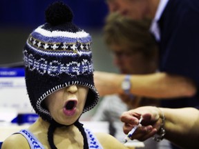 A scared boy pulls his hat over his face while being vaccinated in Rotterdam, the Netherlands.