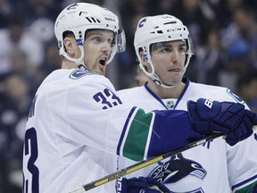 The Vancouver Canucks' Henrik Sedin and Alex Burrows in action against the Winnipeg Jets on March 12, 2014 in Winnipeg. CP photo.